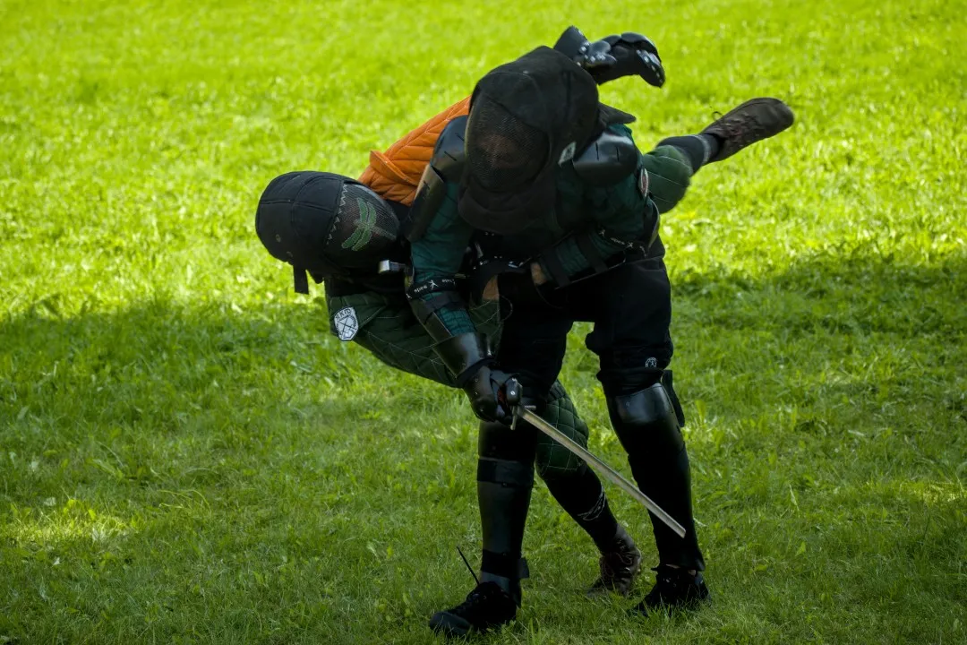 Wrestling action during a longsword bout on grass