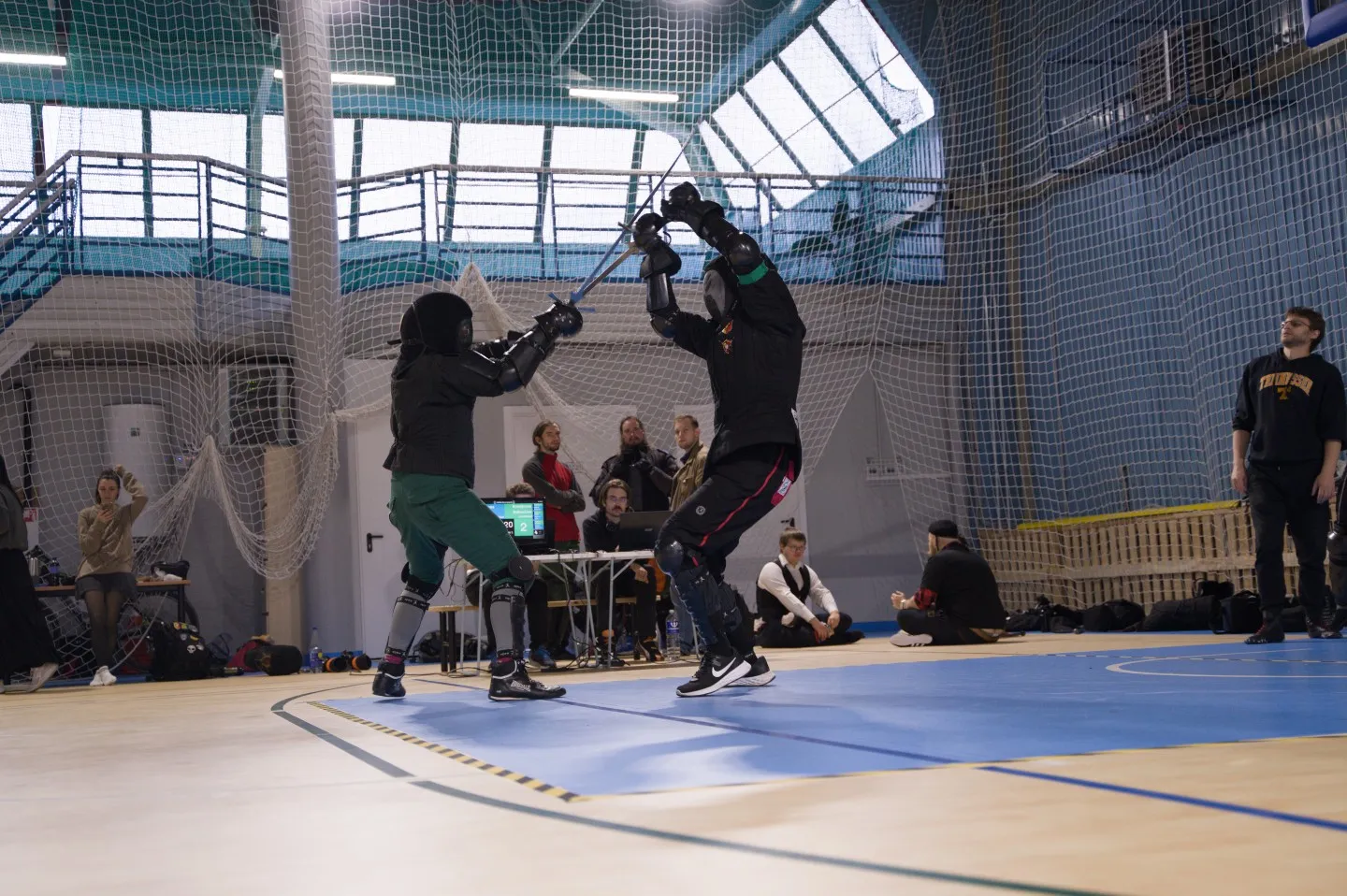 Longsword bout on a tournament ring in an indoor arena